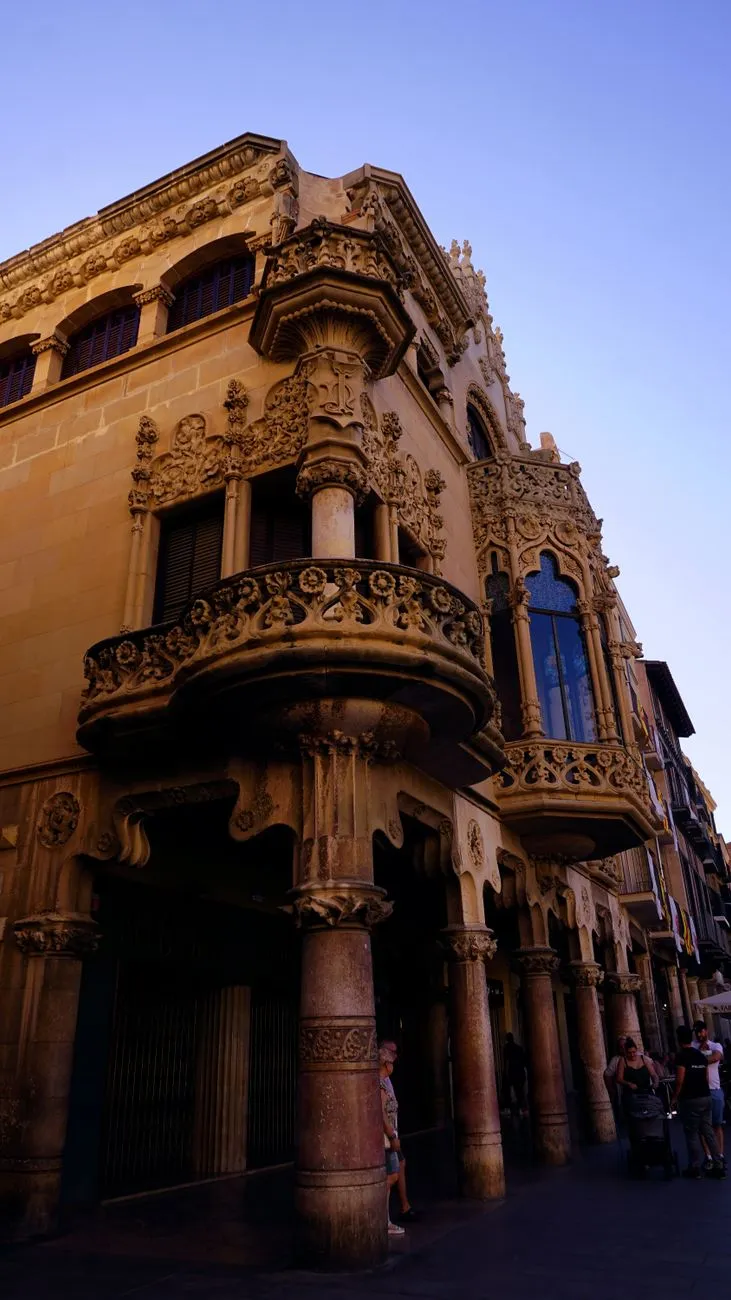 La esquina de la Casa Navàs en Reus, con su balcón corrido de piedra labrada y las columnas de la planta baja sobre la plaza del Mercadal.